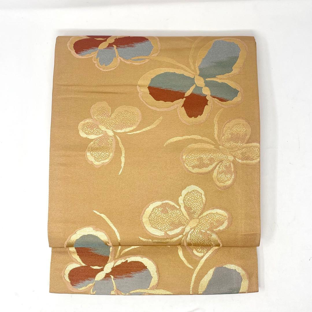 ［ 名古屋帯/ポリエステル ］化繊　柔らかい橙系の色　蝶　洗濯　洗える