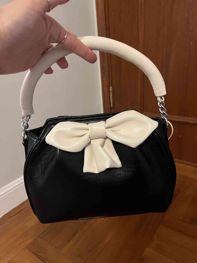 リボン付き黒と白のハンドバッグ